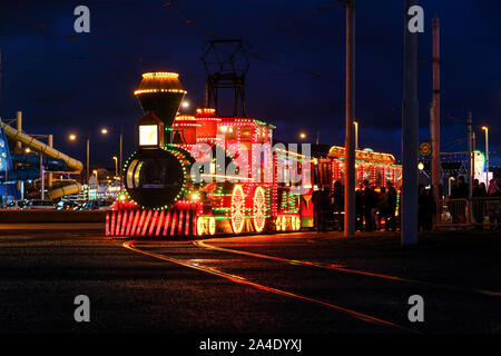 Les passagers se préparent à bord d'un tram lumineux pour une tournée à travers les enluminures. Banque D'Images