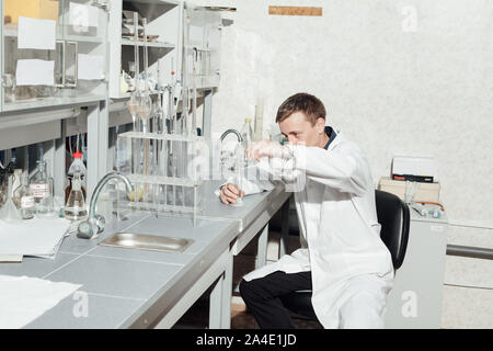 Jeune scientifique effectue des expériences chimiques au laboratoire Banque D'Images