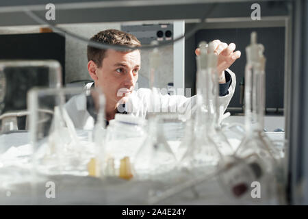 Jeune scientifique effectue des expériences chimiques au laboratoire Banque D'Images