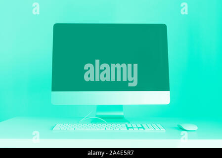 Clavier, souris, écran de l'ordinateur avec écran vide noir. Couleur turquoise et vert à la mode. Espace créateur sur fond couleur menthe. Le style minimaliste Banque D'Images