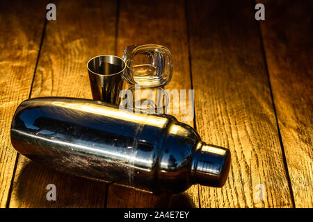 Shaker accessoires et verres à sur une planche de bois. Banque D'Images
