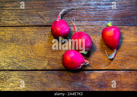 Les radis rouges frais sur une planche de bois. Banque D'Images