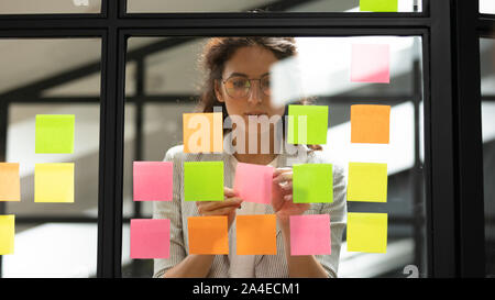 Businesswoman Créer liste de tâches avec des notes autocollantes multicolores Banque D'Images