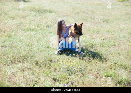 Berger Allemand trains femme en parc sur marche Banque D'Images