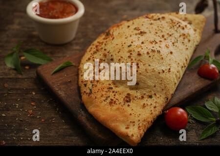 - CheesePizza italien Calzone repliée sur fond de bois rustique Banque D'Images