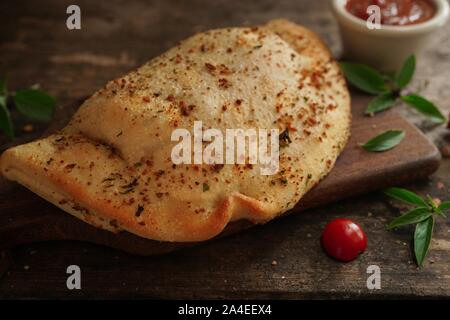 - CheesePizza italien Calzone repliée sur fond de bois rustique Banque D'Images