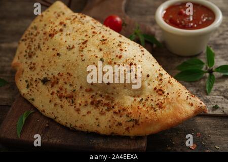 - CheesePizza italien Calzone repliée sur fond de bois rustique Banque D'Images