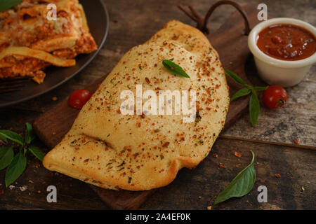 - CheesePizza italien Calzone repliée sur fond de bois rustique Banque D'Images