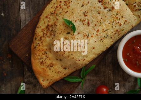 - CheesePizza italien Calzone repliée sur fond de bois rustique Banque D'Images