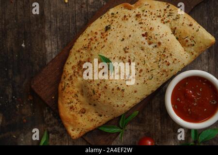 - CheesePizza italien Calzone repliée sur fond de bois rustique Banque D'Images