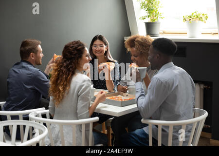 Multi-ethnic friendly vos collègues pendant le déjeuner eating pizza Banque D'Images