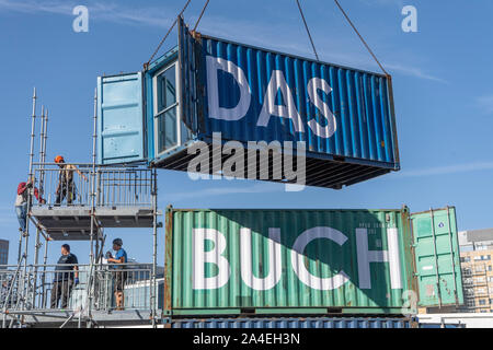 Francfort, Allemagne. 14 octobre 2019, Hessen, Frankfurt/Main : Avec l'aide d'une grue, d'expédier des conteneurs sont empilées pour former une cabine de l'installation. La Foire du livre sera ouvert officiellement le mardi (15.10.). Photo : Boris Roessler/dpa dpa : Crédit photo alliance/Alamy Live News Banque D'Images