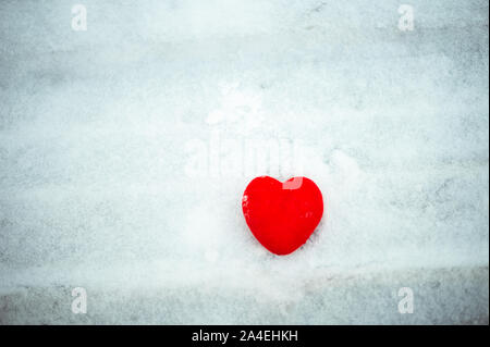 Belle vintage romantique cœur rouge sur un fond blanc neige hiver. Banque D'Images