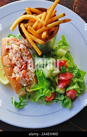 Un rouleau de homard sandwich avec une salade verte et de frites Banque D'Images