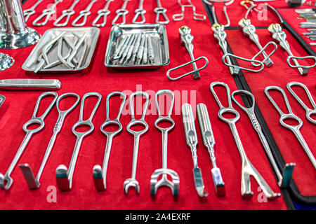 Les instruments chirurgicaux et les outils mis à disposition sur une toile rouge. Banque D'Images