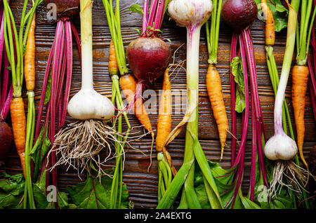 Arrière-plan de végétariens produits frais bio betterave ail vert et des carottes sur la table de cuisine rustique en bois Banque D'Images