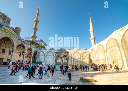 Les touristes, les visiteurs musulmans fidèles, et visiter l'intérieur square à l'intérieur de la Mosquée Bleue, dans le quartier de Sultanahmet d'Istanbul, Turquie. Banque D'Images