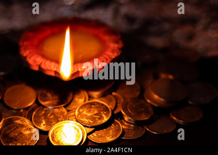 Vue de dessus d'une lampe en terre dans le noir brillant avec de l'argent à l'avant-plan pour la prospérité en Lakshmi pooja pendant Diwali Banque D'Images