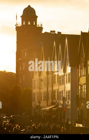 La foule à la piscine tables dans Bryggen sur une chaude soirée d'été. Bryggen, Bergen, Norvège, Europe Banque D'Images