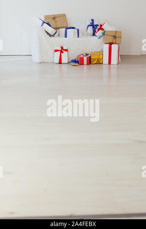 Beaucoup de cadeaux colorés sur le canapé dans l'intérieur de la chambre blanche Banque D'Images