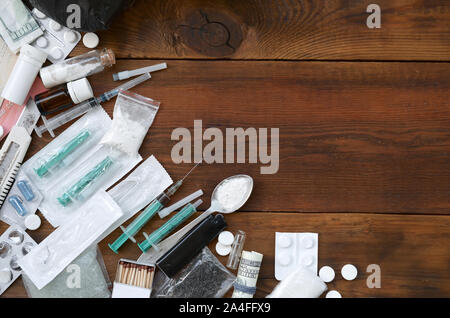 Beaucoup de substances narcotiques et dispositifs pour la préparation de médicaments se trouvent sur une vieille table en bois. Revendeur de drogue. La cocaïne et le cannabis en complète Banque D'Images