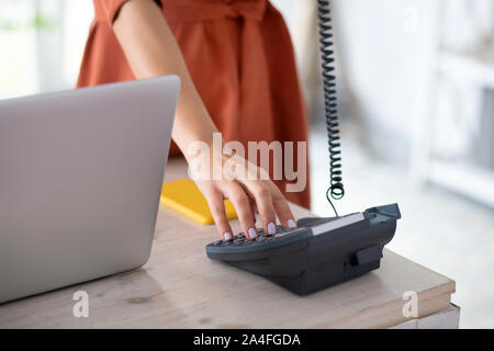 Close up of woman dialing number tout en travaillant au bureau Banque D'Images