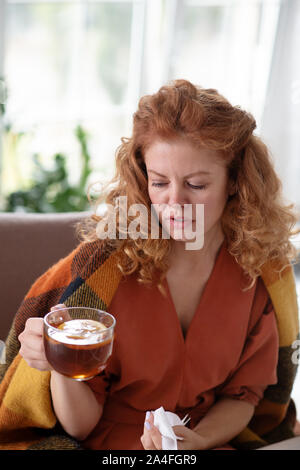 Femme à boire le thé au citron avec sensation de froid alors que Banque D'Images