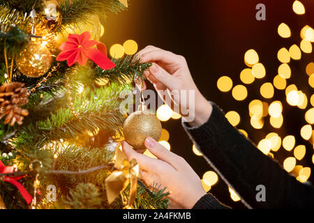 Girl décore un arbre de Noël. Libre de droit des femmes la décoration de sapin de Noël. Se concentrer sur sa main gauche ! Banque D'Images