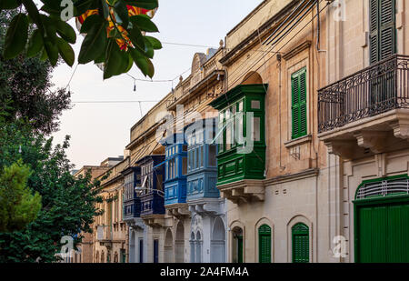 Façade de maison résidentielle avec balcons en bois traditionnelle maltaise à Sliema, Malte, colorée en orange avec la lumière du soleil du soir. Urbain maltaise authentique Banque D'Images