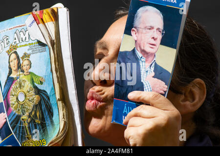 Un supporter tient dans ses mains les photos de l'ancien président Alvaro Uribe Banque D'Images