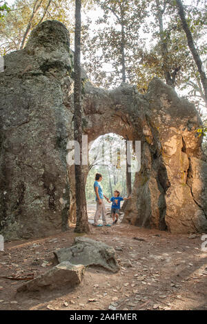 Une jeune mère tenant son fils main sous une arche naturelle de roches dans El Arquito, Huasca de Ocampo, Hidalgo, Mexique. Banque D'Images