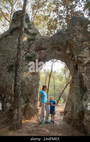 Une jeune mère tenant son fils main sous une arche naturelle de roches dans El Arquito, Huasca de Ocampo, Hidalgo, Mexique. Banque D'Images