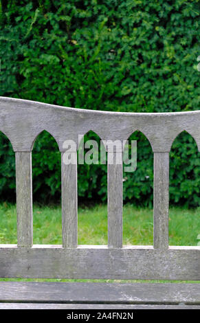 Détail de l'arc gothique de l'arrière d'un fauteuil de jardin en bois dans un jardin anglais Banque D'Images