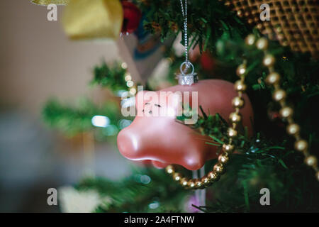 Les jouets de Noël sous la forme d'un cochon rose sur une décoration de Noël arbre de Noël. Close-up. Banque D'Images