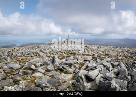 Le robuste et rocky télévision haut de Muckish Mountain à Donegal Irlande. Dans la distance est une croix dessus de l'un des points les plus élevés de la montagne Banque D'Images