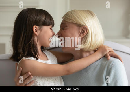 Granny d'âge moyen heureux de toucher le nez avec mignon petite-fille. Banque D'Images