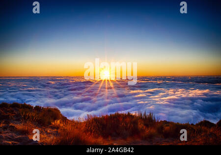 Nature fond avec le lever du soleil sur les nuages. C'est sur le haut de la montagne Pico do Arieiro, l'île de Madère, au Portugal. Le soleil levant a une couleur d'or. Banque D'Images