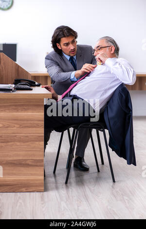 L'employé de sexe masculin souffrant d'une crise cardiaque dans le bureau Banque D'Images