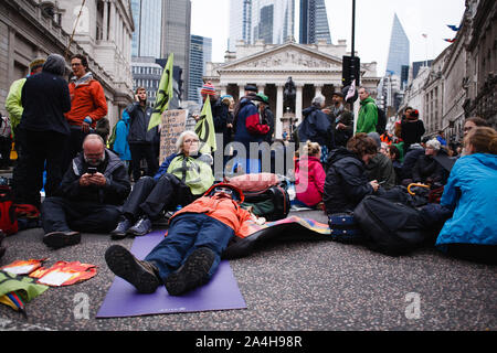 Les militants du mouvement de rébellion d'Extinction le bloc de jonction de la Banque à l'extérieur de la Banque d'Angleterre pendant la manifestation.Aujourd'hui a marqué le début de la deuxième semaine consécutive d'actions de protestation par XR sont les membres réunis à Londres, plus de 1 400 d'entre eux ont été arrêtés dans la ville pour leur disruptiveness non violent ouvertement depuis lundi dernier. Les arrestations sont considérés comme un élément tactique par le groupe, conçu pour maximiser la publicité et la perturbation et ainsi de renforcer la pression sur les dirigeants politiques à prendre plus vite et l'action sur les changements climatiques et la perte de biodiversité. Le blocus de la rébellion d'extinction Banque D'Images