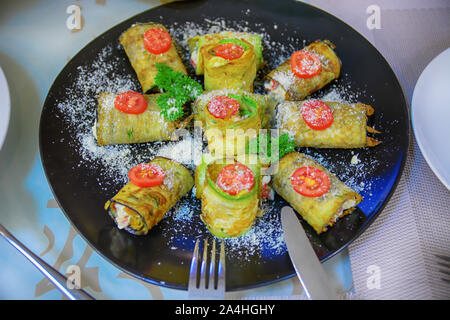 Rouleaux végétariens avec des courges, tomates, fromage et de verdure sur la plaque noire. Focus sélectif. Alimentation saine. Banque D'Images