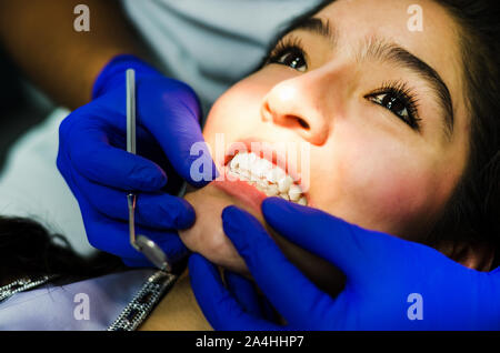 La femme est venue pour voir le dentiste. Elle s'assoit sur le fauteuil dentaire. Le dentiste se pencha sur elle. Heureux patient et dentiste concept. Banque D'Images