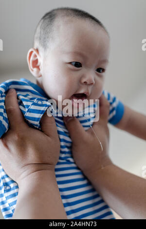 Père holding baby son lever en l'air. baby boy et passionnant de bave. Banque D'Images