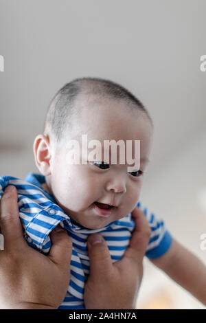 Père holding baby son lever en l'air. baby boy passionnant. Banque D'Images