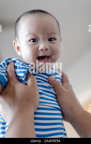 Père holding baby son lever en l'air. baby boy et passionnant de bave. Banque D'Images