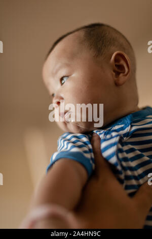 Père holding baby son lever en l'air. baby boy et passionnant de bave. Banque D'Images