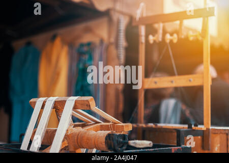 Rouet traditionnel machine permettant de fabriquer de la soie naturelle ver à soie. Les fibres de soie à l'emballage de la poulie dans le bazar. Banque D'Images