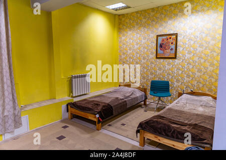 Hostel La classe inférieure rez de chaussée chambre à coucher avec deux lits séparés et un président de couleur bleu Banque D'Images