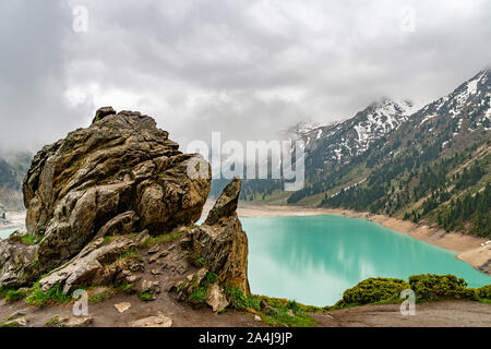 Le lac pittoresque Big Almaty à couper le souffle de rock avec une montagne d'un jour de pluie et brouillard Banque D'Images