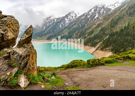 Le lac pittoresque Big Almaty à couper le souffle de rock avec une montagne d'un jour de pluie et brouillard Banque D'Images