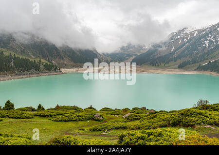 Big Almaty Lake High Angle View pittoresque à couper le souffle avec des montagnes enneigées sur un jour de pluie et brouillard Banque D'Images